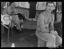 Unemployed lumber worker goes with his wife to the bean harvest. Note social security number tattooed on his arm. Oregon.