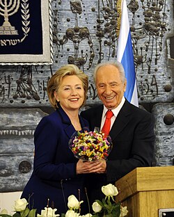 Clinton with the Israeli President, Shimon Peres in 2009. Behind them is an Israeli artwork made of basalt ash.