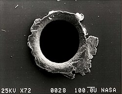 View of an orbital debris hole made in the panel of the Solar Max satellite