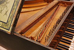 Harpsichord by Christian Zell, at Museu de la Música de Barcelona. From upper left to lower right: a bridge (supporting the far ends of the strings), the jack rail with the action (jacks) underneath, two nuts (supporting the closer ends of the strings), interleaved with two rows of tuning pins, and finally the keyboard. As with all harpsichords, the action itself is mostly hidden by the jack rail when the instrument is being played; only by removing the jack rail (or indeed, by extracting a jack) can the details of the action be observed.