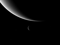 Neptune and its moon Triton, taken by Voyager 2. Triton's orbit will eventually take it within Neptune's Roche limit, tearing it apart and possibly forming a new ring system.