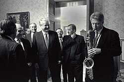 Clinton plays the saxophone presented to him by Russian president Boris Yeltsin at a private dinner in Russia, January 13, 1994.