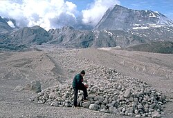 A scientist examines pumice blocks at the edge of a pyroclastic flow deposit from Mount St. Helens