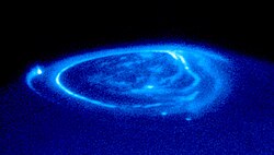 Jupiter aurora; the far left bright spot connects magnetically to Io; the spots at the bottom of the image lead to Ganymede and Europa.