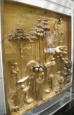 Side view of Lorenzo Ghiberti's cast gilt-bronze Gates of Paradise at the Florence Baptistery in Florence, Italy, combining high-relief main figures with backgrounds mostly in low relief.