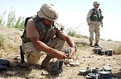 A US Army Explosive Ordnance Disposal technician removing the fuze from a Russian-made mine to clear a minefield outside of Fallujah, Iraq
