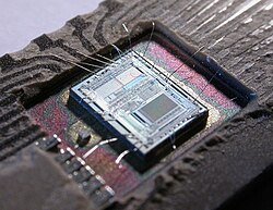 The die from an Intel 8742, an 8-bit NMOS microcontroller that includes a CPU running at 12 MHz, 128 bytes of RAM, 2048 bytes of EPROM, and I/O in the same chip