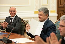 Poroshenko showing the law signed. Chairman of the Ukrainian parliament Andriy Parubiy is on the left