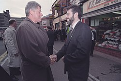 Clinton shaking hands with Gerry Adams outside a business in East Belfast, November 30, 1995