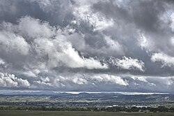 View of southern Rapid City from the east after a rainstorm, including a view of Black Elk Peak and the Black Hills