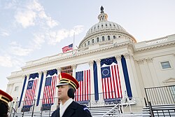 Flag decorations at the Capitol as being prepared for Trump's inauguration in 2025, featuring a pair of Betsy Ross flags alongside a pair of 27-star flags – representing the President's home state of Florida when it was admitted to the Union as the 27th state. The main flag on the flagpole was noticeably displayed at half-staff in honor of Jimmy Carter.