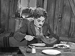 Charlie Chaplin eating a boot in his film The Gold Rush