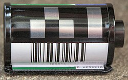 This modern film canister uses DX encoding; it is marked with a six-digit barcode which embeds the DX number below a silver-and-black conductive DX Camera Auto Sensing pattern.