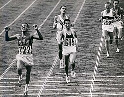 Billy Mills crosses the finish line at the end of the 10,000-meter race at the 1964 Tokyo Olympics.