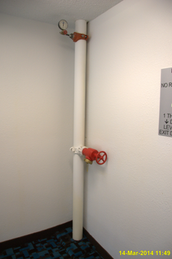 Standpipe equipped with pressure gauge in the stairwell of a Texas hotel