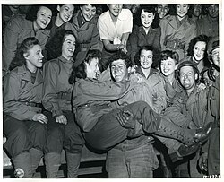 Female USO troupe entertaining an American soldier, 1944.