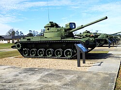 An M60 tank with an infrared searchlight mounted on the cannon.