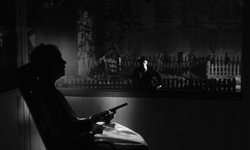 A lighting arrangement in The Night of the Hunter. Note the placement of the key light off the subject (Lillian Gish) to create a silhouette while illuminating Robert Mitchum in the background. This plays off the conventional association of light with good and darkness with evil.