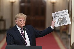 Trump holding a newspaper mentioning his acquittal by the Senate during his first impeachment trial in February 2020
