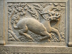 Gilin with the head and scaly body of a dragon, tail of a lion and cloven hoofs like a deer. Its body enveloped in sacred flames. Detail from Entrance of General Zu Dashou Tomb (Ming Tomb).
