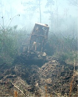 A bulldozer plows a control line in advance of a wildfire in Georgetown, South Carolina.