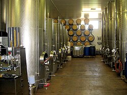 Stainless steel fermentation vessels and new oak barrels at the Three Choirs Vineyard, Gloucestershire, England