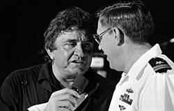 Cash singing with U.S. Navy lieutenant during a military event, c. January 1987