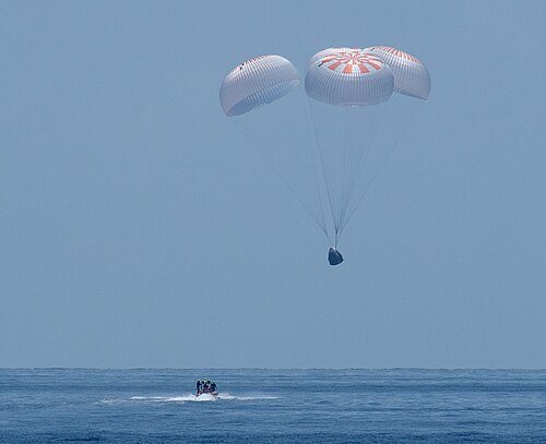 A SpaceX Crew Dragon capsule splashes down.
