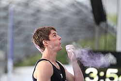Climber Jan Hojer blows surplus chalk from his hand. Boulder World Cup 2015