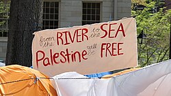 A banner with the text "from the river to the sea, Palestine will be free," displayed at an encampment in solidarity with Palestinians during the Gaza war and genocide at Harvard University, May 2024.