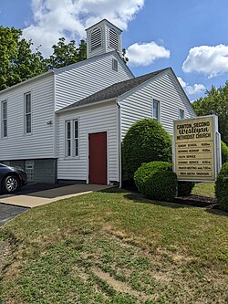The sign of this Wesleyan Methodist church displays the times for the Sunday morning service of worship and Sunday evening service of worship, consistent with the historical first-day Sabbatarian doctrine of Methodism to hallow the Lord's Day. The midweek Wednesday prayer service is indicated on the sign as well.