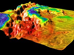This 3D view depicts the border between the lowland plains on the right and the crustal plateau region of Ovda Regio on the left