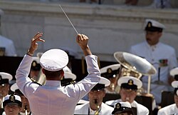 A military conductor leads the U.S. Navy band during Memorial Day ceremonies held at Arlington National Cemetery.