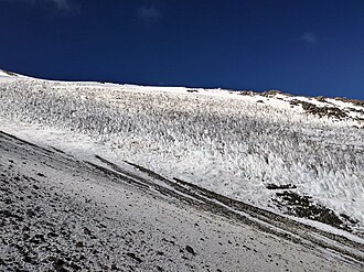 Tooth-like snow forms on a medium-steep slope of a mountain.