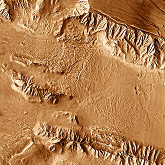 Deposits from landslides moving in opposite directions meet on the canyon floor near the junction of Melas and Coprates chasmata.
