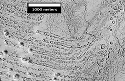 HiRISE image of possible rootless cones east of Elysium region. The chains of rings are interpreted to be caused by steam explosions when lava moved over ground that was rich in water ice.