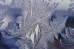 Water vapor from humid winter air deposits directly into a solid, crystalline frost pattern on a window, without ever being liquid in the process.