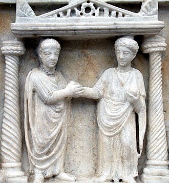 Couple clasping hands in marriage, idealized by Romans as the building block of society and as a partnership of companions who work together to produce and rear children, manage everyday affairs, lead exemplary lives, and enjoy affection[53]
