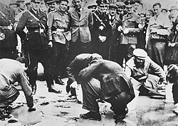 Austrian Nazis and local residents watch as Jews are forced to scrub the pavement, Vienna, March 1938