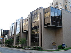 A street level view of Salk Hall, the primary location of the School of Pharmacy. The Commonwealth of Pennsylvania historical plaque honoring Jonas Salk's research conducted in the building that resulted in the first polio vaccine can be seen at the bottom right