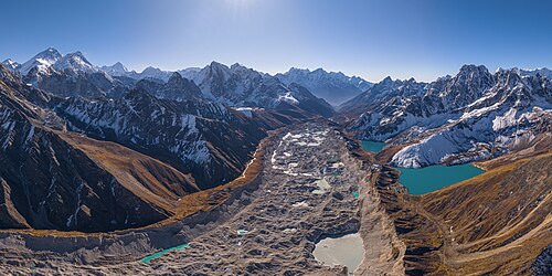 Aerial view of the southern end of the Ngozumpa glacier in the Sagarmatha National Park of Nepal, showing the Gokyo village and lakes on the right, and Everest, Lhotse and Makalu, three of the world's five highest peaks, on the left; view south from Cho Oyo towards the Dudh Kosi valley.