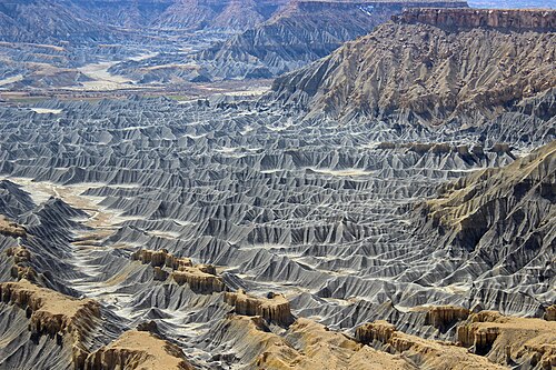 Badlands incised into shale at the foot of the North Caineville Plateau, Utah, within the pass carved by the Fremont River and known as the Blue Gate. G. K. Gilbert studied the landscapes of this area in great detail, forming the observational foundation for many of his studies on geomorphology.[1]