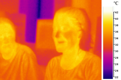 A false-color image of two people taken in long-wavelength infrared (body-temperature thermal) radiation