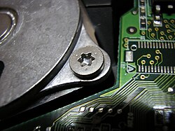 A Torx T8 screw head on a hard disk drive.