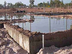 A concrete slab being kept hydrated during water curing by submersion (ponding)